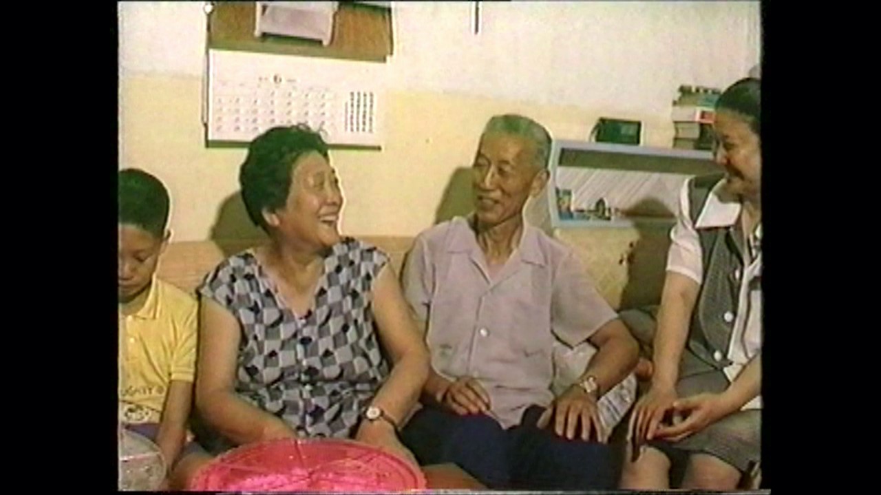 a middle aged couple sit on a couch