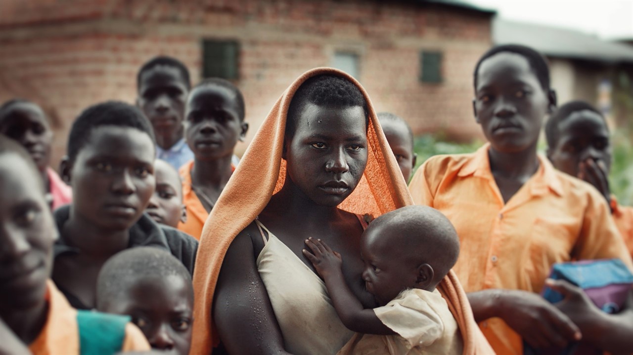 A woman stands wtih a breastfeeding baby