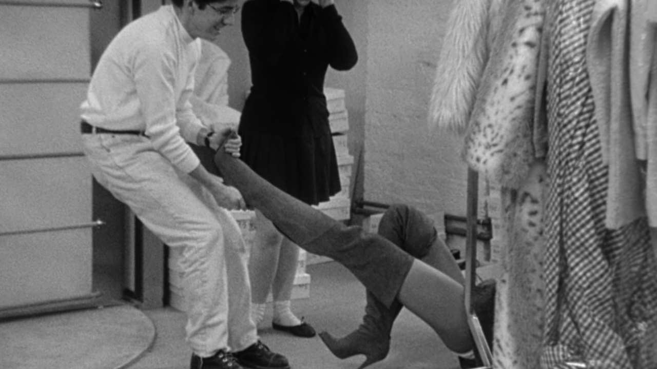 a man with glasses trying to pull off long boots