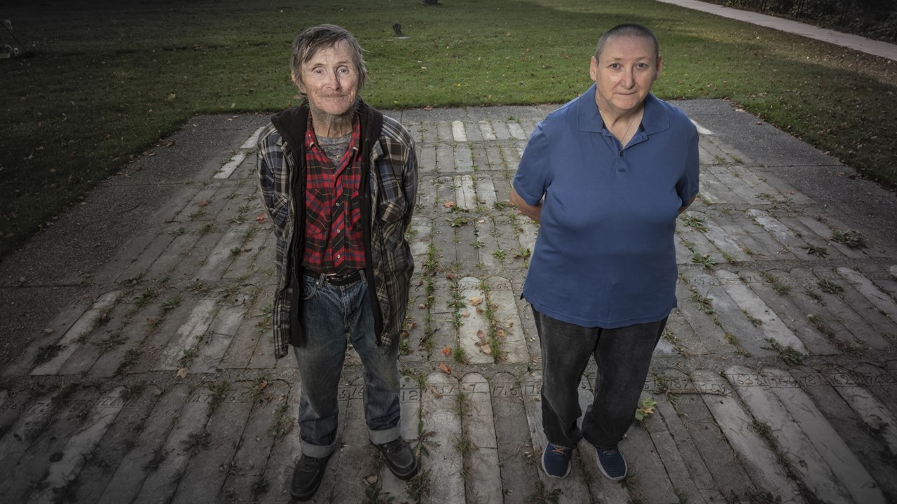 Two people standing on a cement plot