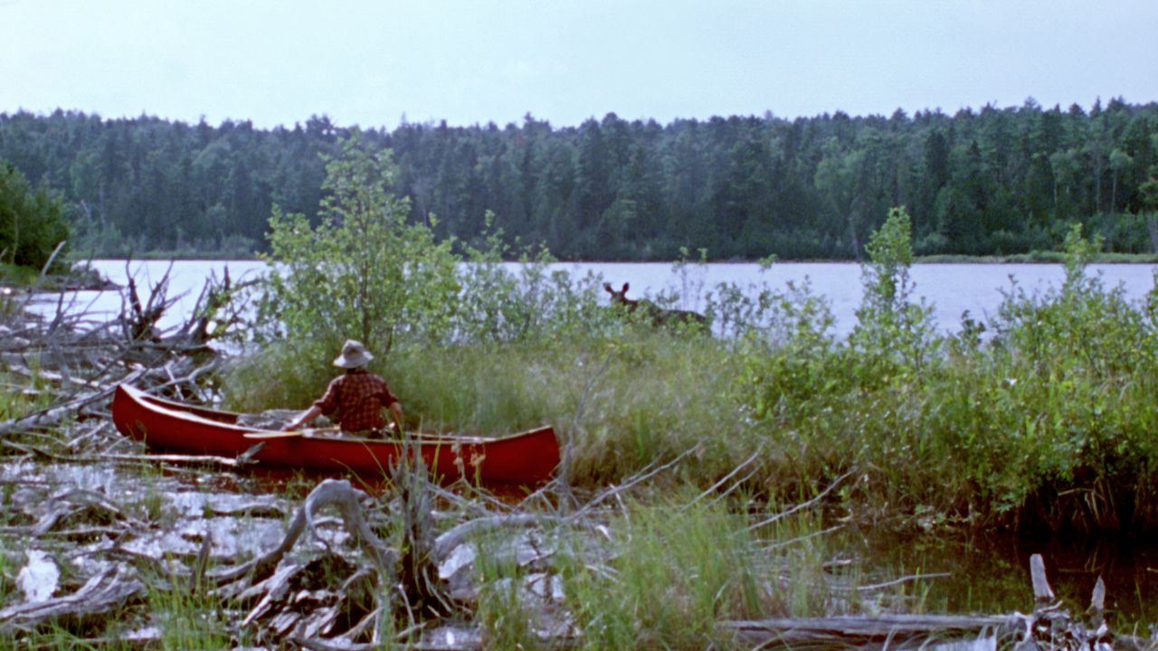 a man with a hat in a canoe