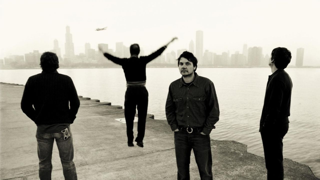 four men standing together on a waterfront