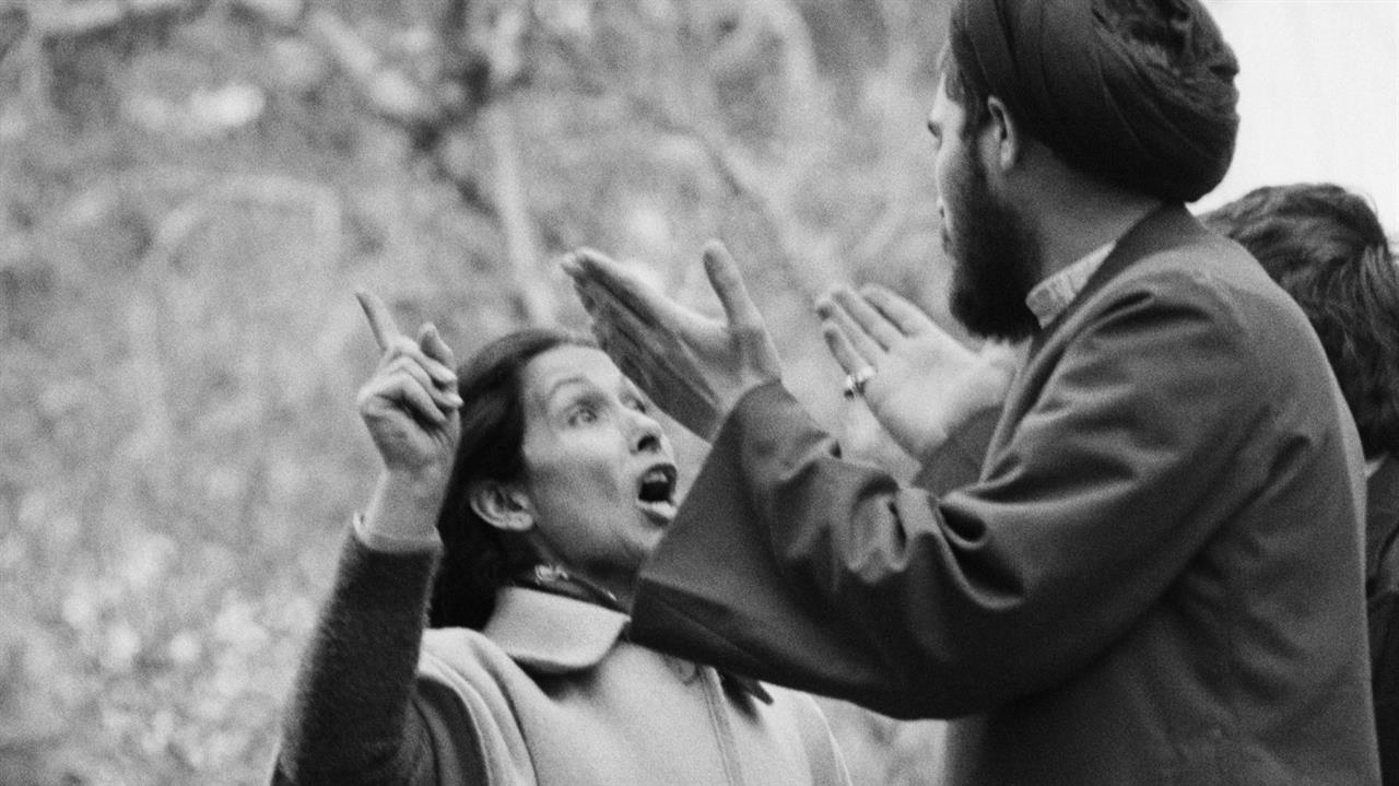 A woman and man, hands raised