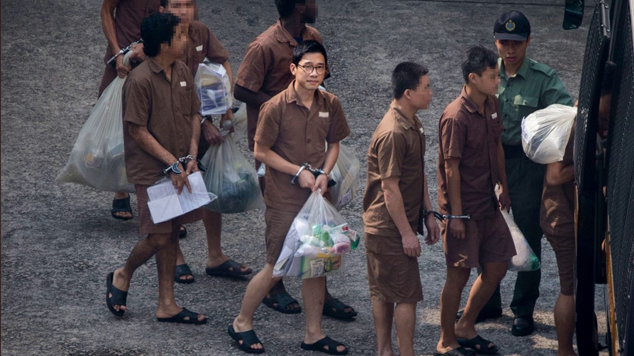 Nathan Law, handcuffed carrying a plastic bag gett