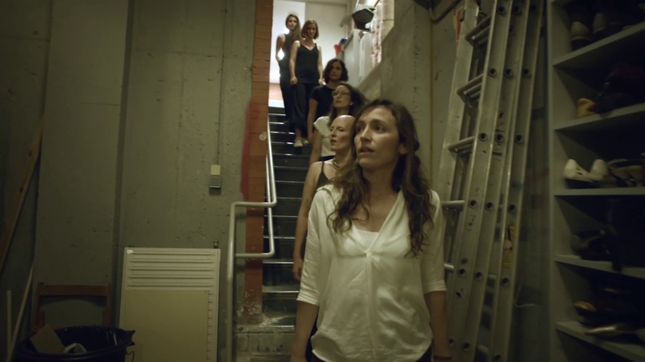 Women walk down stairs into a storage space