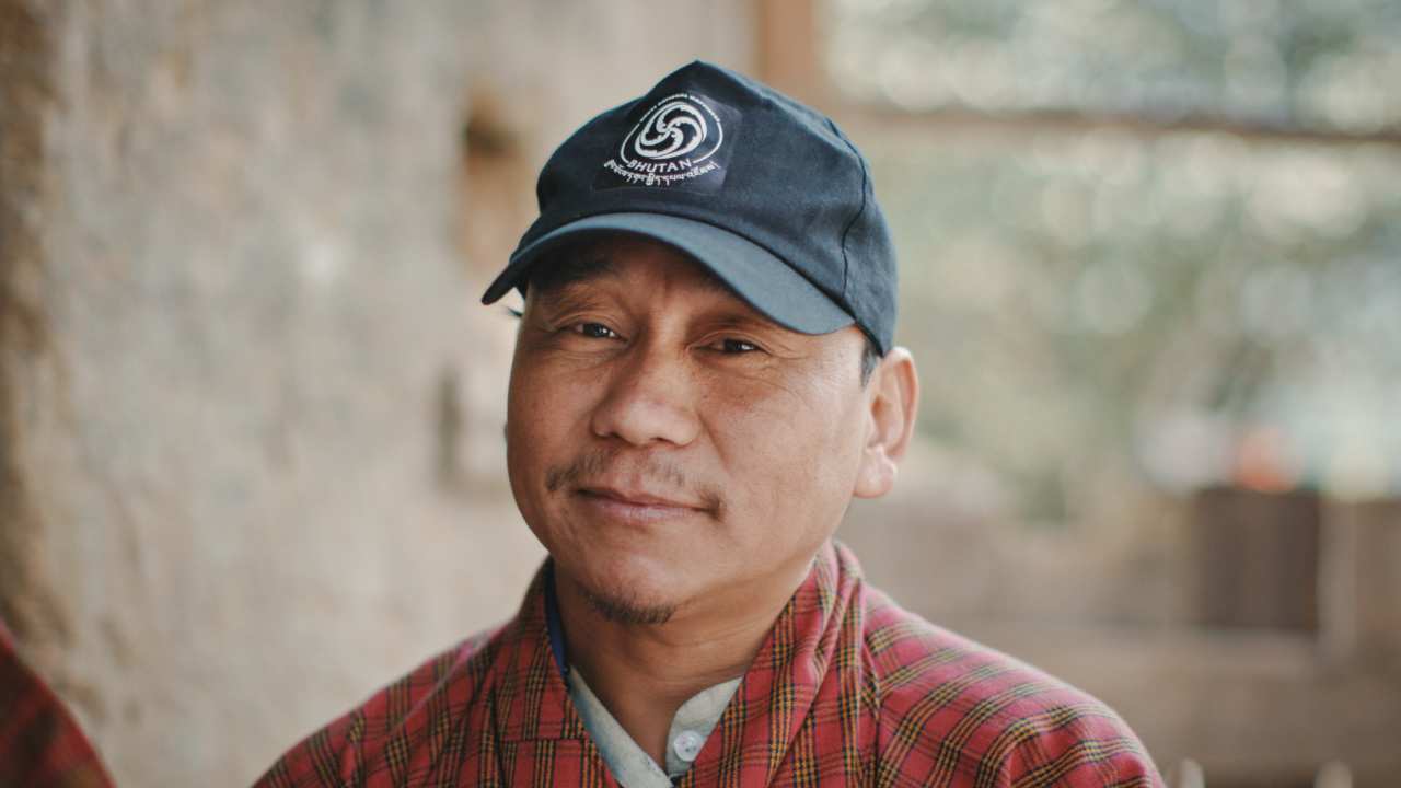 a man with a baseball cap looking at the camera