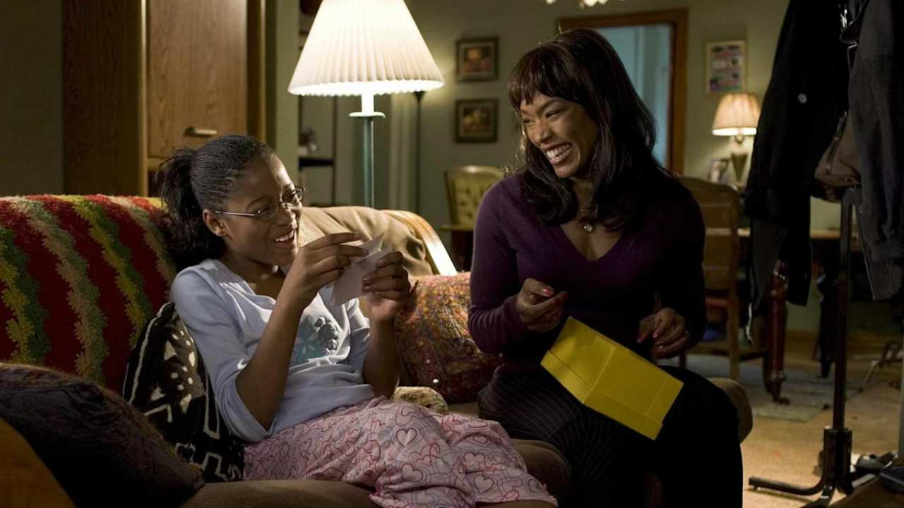 a young girl and her mother sitting on a couch