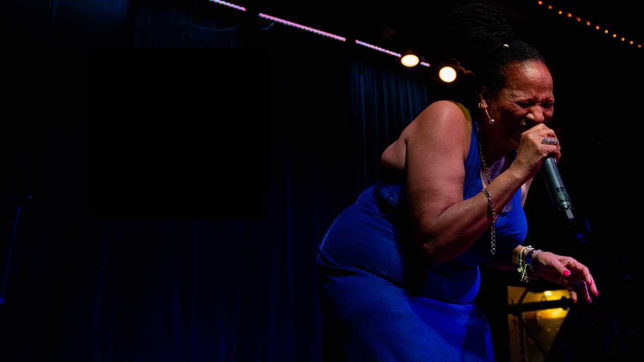 a woman singing into a microphone on stage