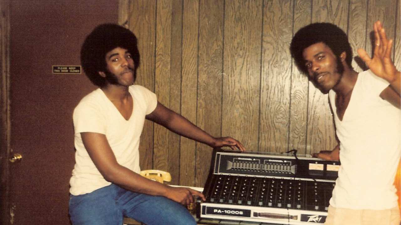 two men standing in front of sound equipment