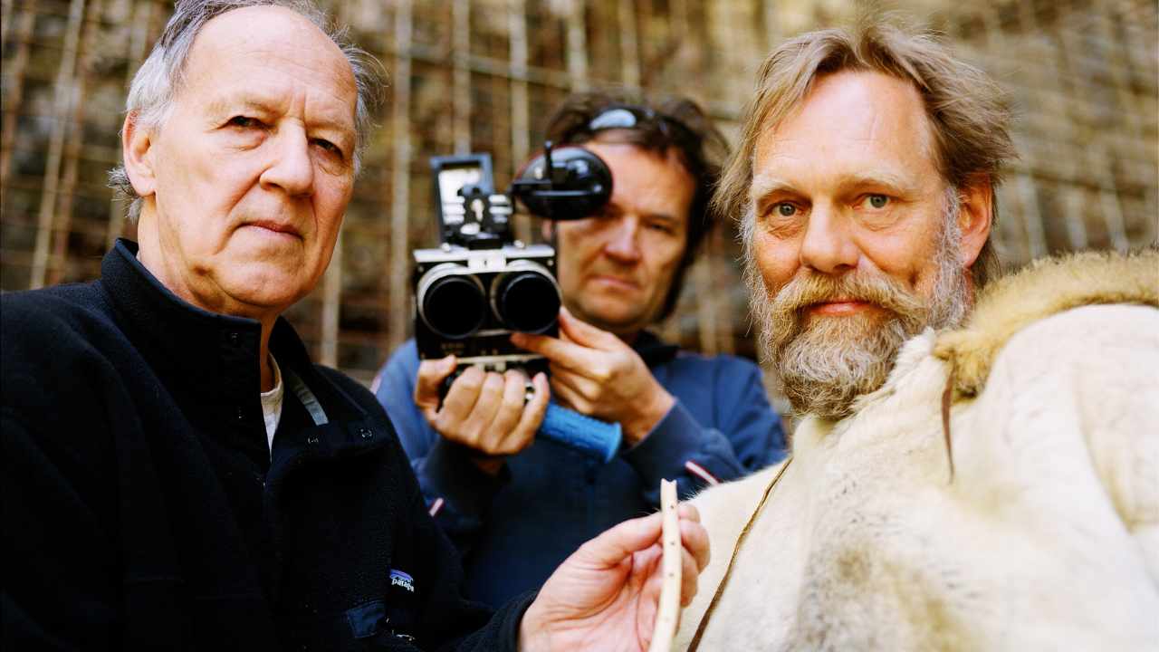 three men standing together with a camera