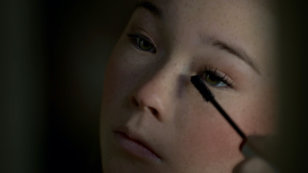 Closeup of a woman putting on mascara