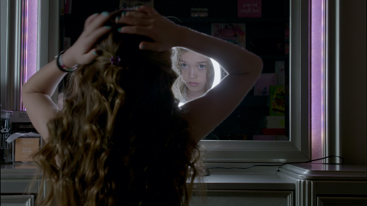 Young girl in front of a mirror doing her hair