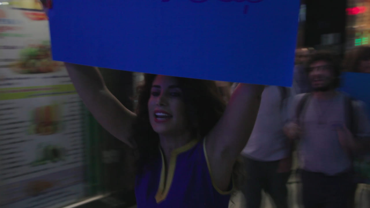 Closeup of a woman with a blue sign