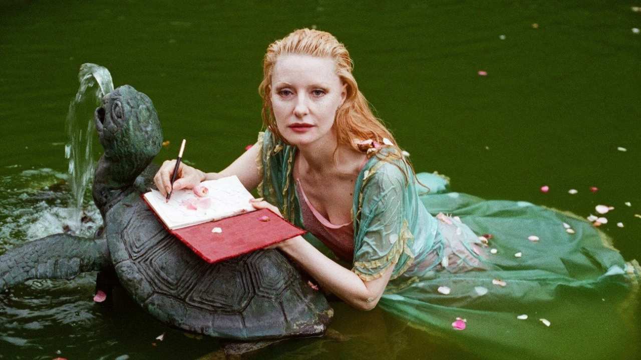 a woman writing in a journal on a turtle fountain