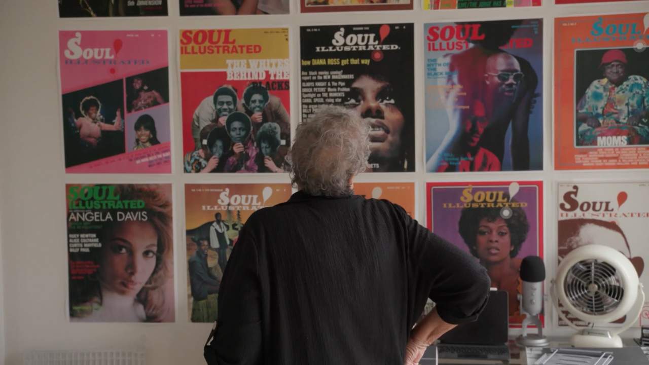 a woman looking at a wall of magazine covers