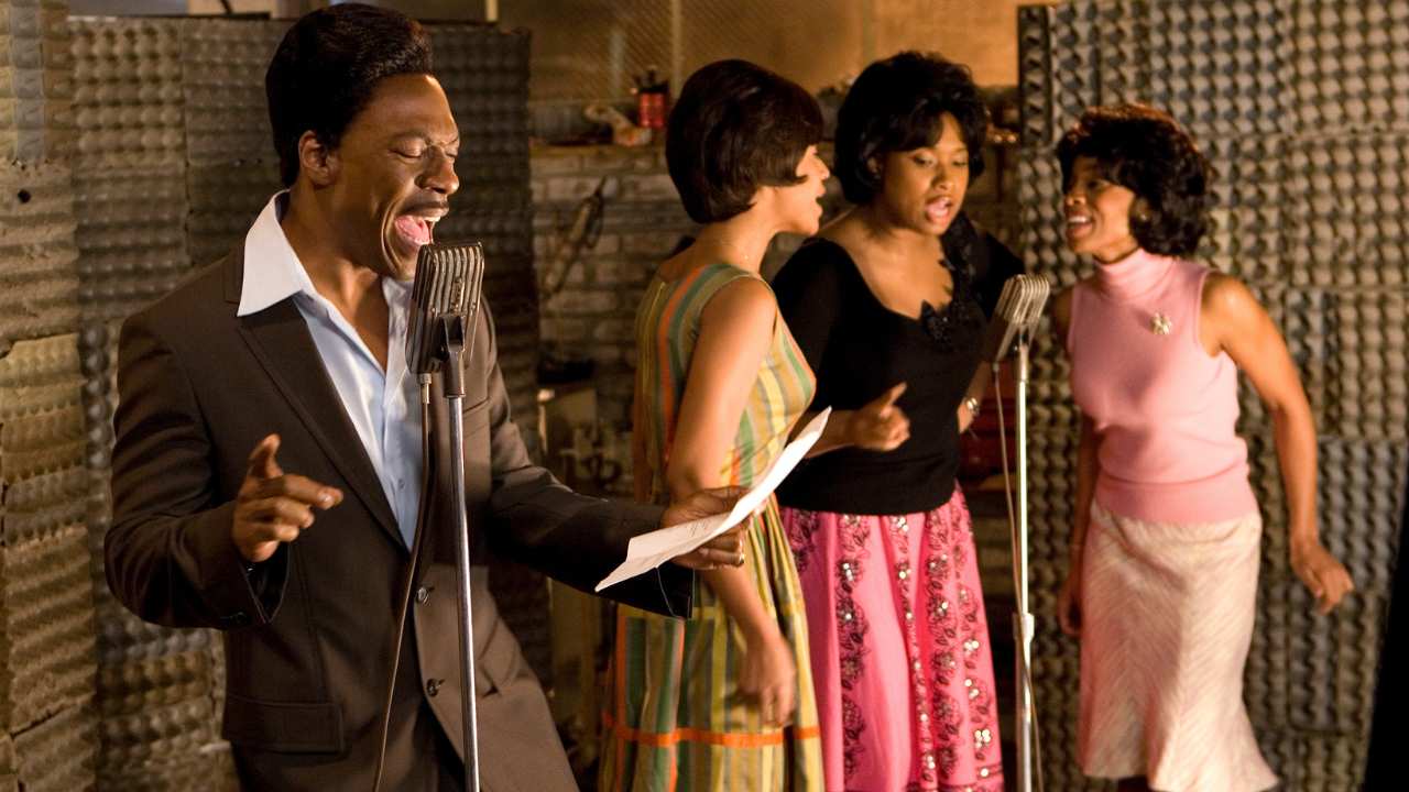 a man and three women singing into microphones