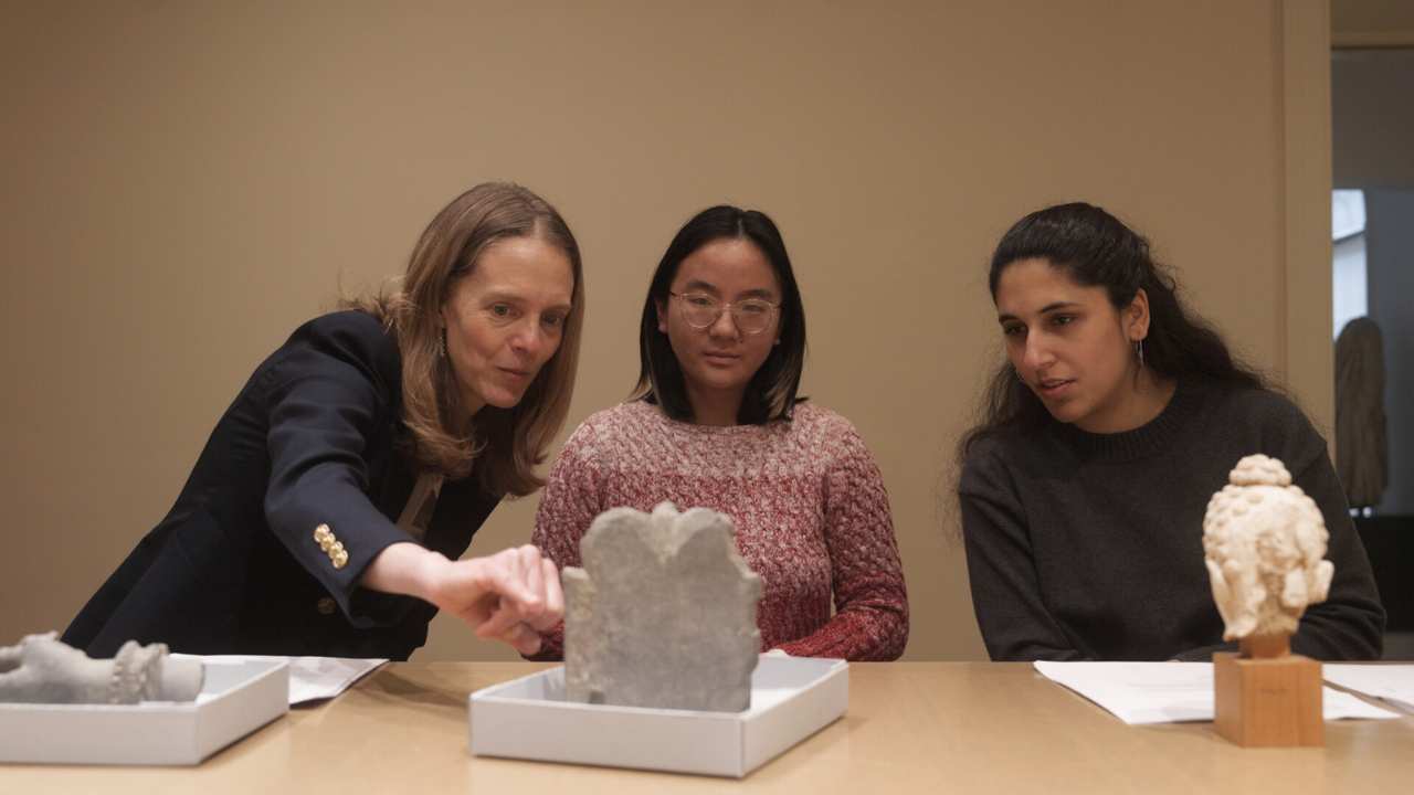 three women looking at artifacts together