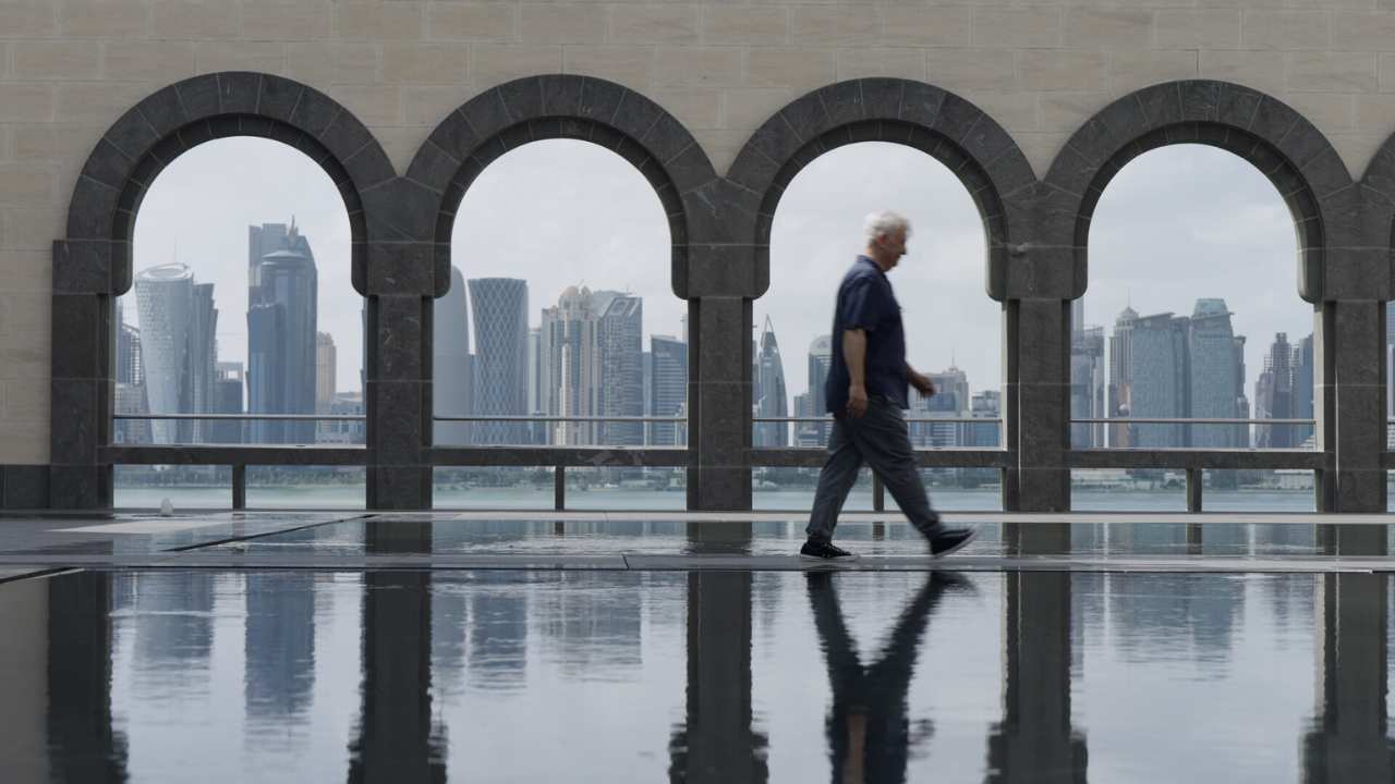 a man walking in front of four archways