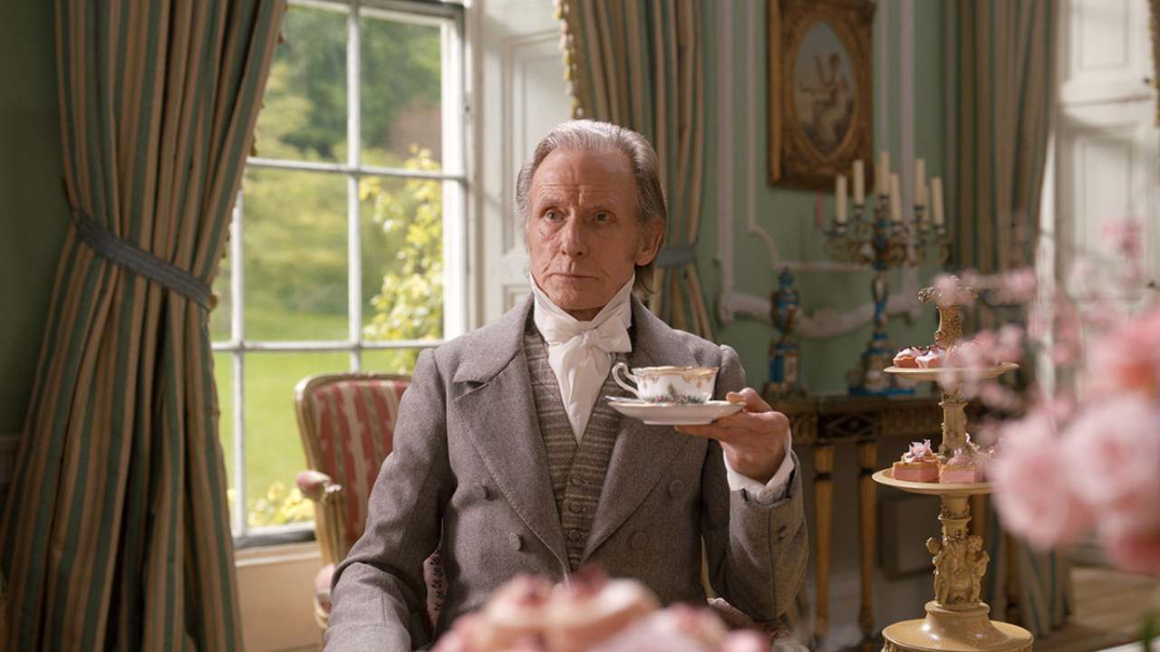 a man sitting and holding a cup of tea