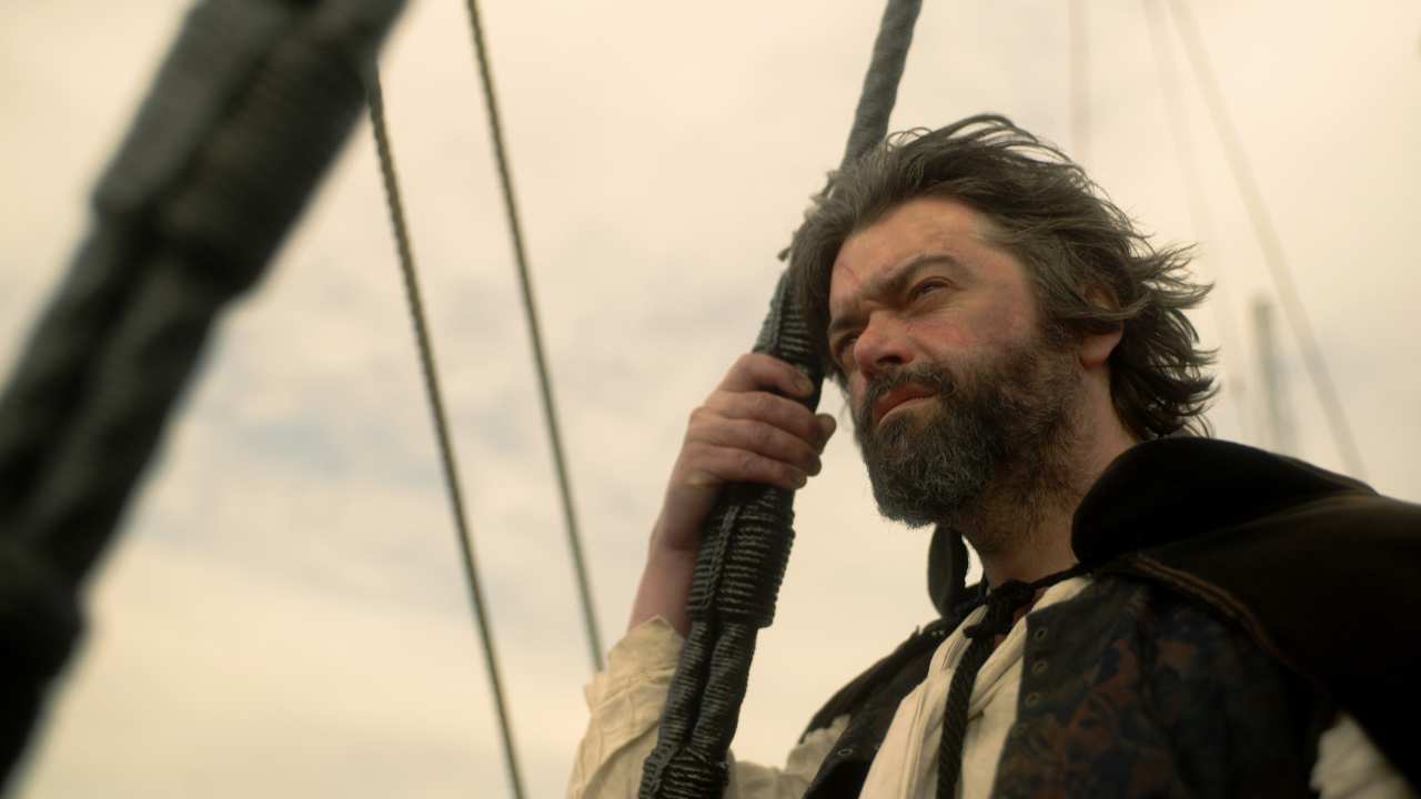 a bearded man standing on a ship