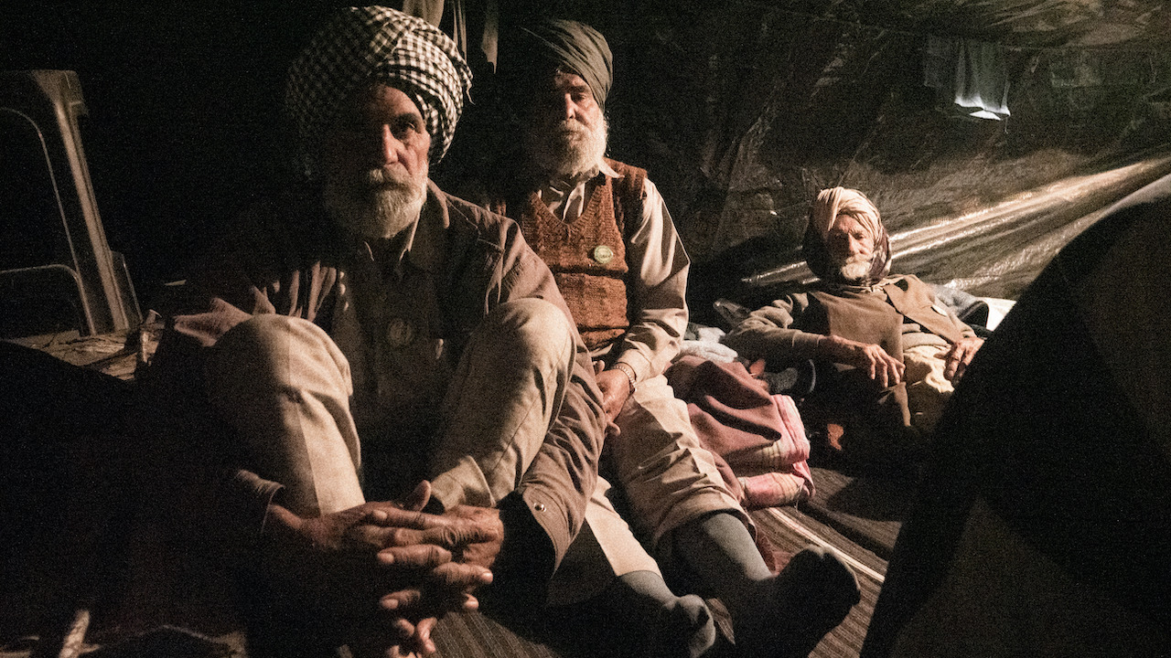 Three men sitting in a dimly lit space