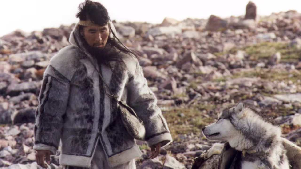 a man with long hair walking with a dog