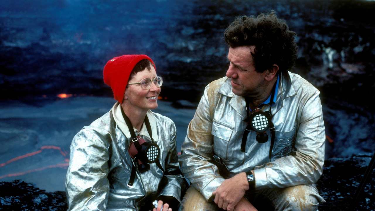 a woman and man in matching silver jackets