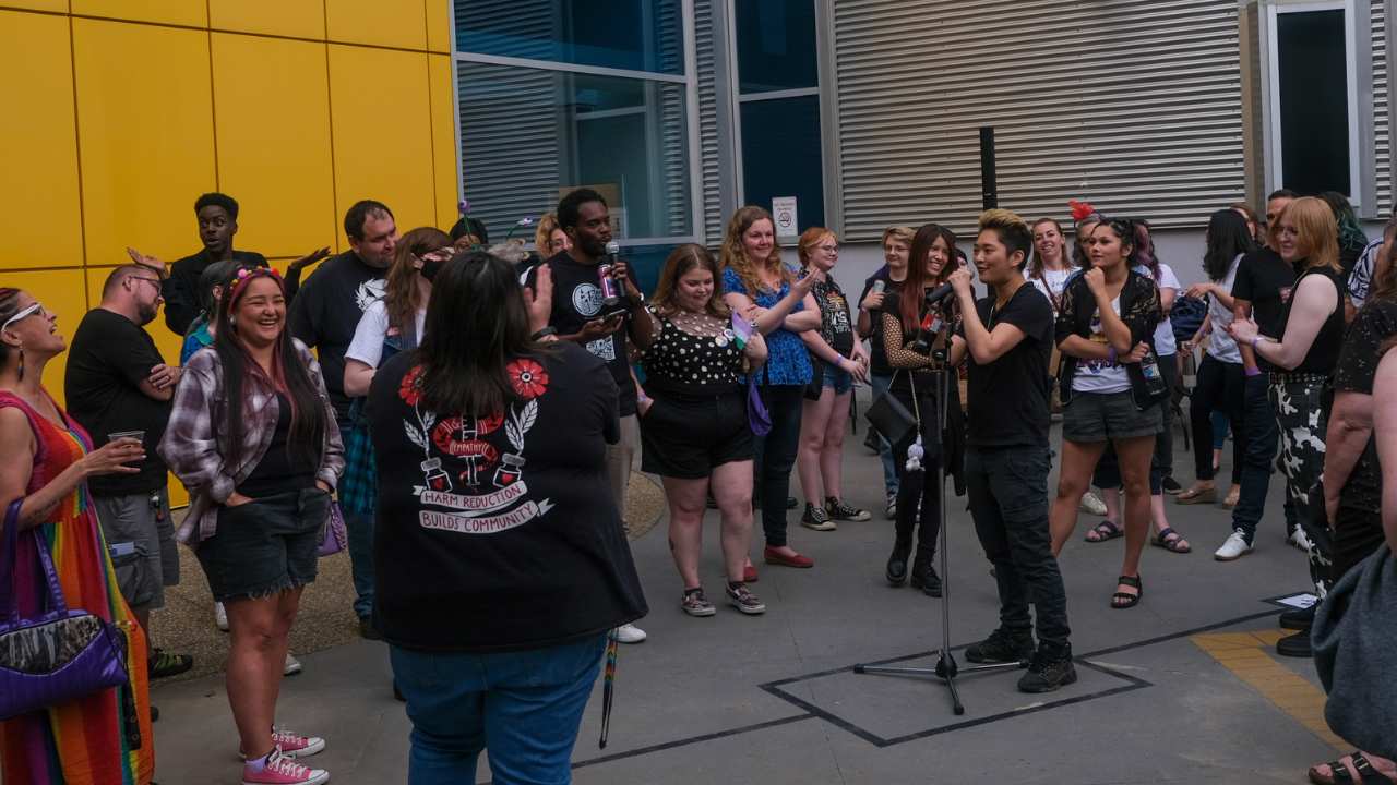 two people with microphones talking to a crowd