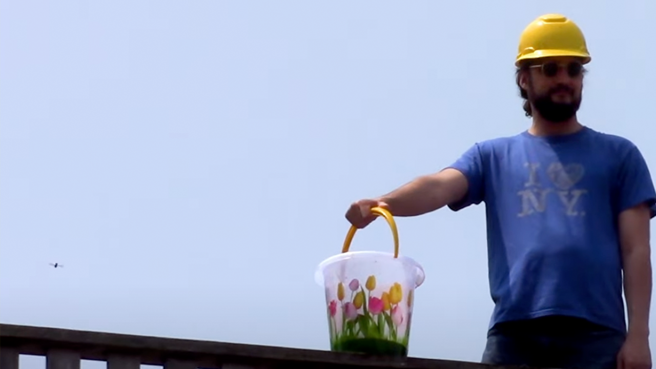 a man in a helmet holds a bucket