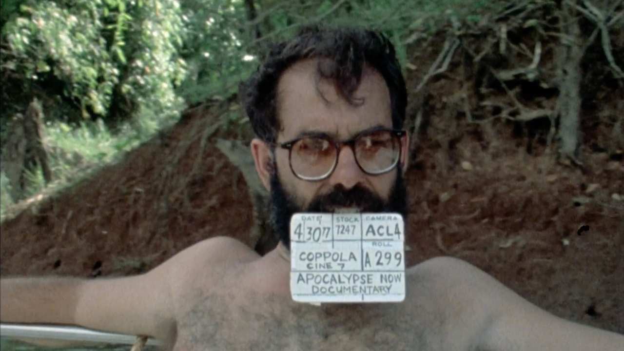 a man with a beard holding paper with his teeth