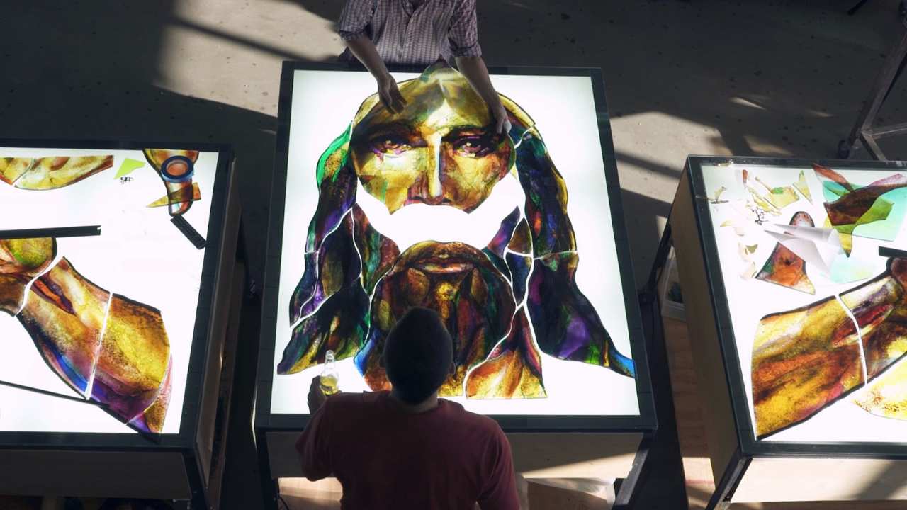 two people assembling a stained glass face