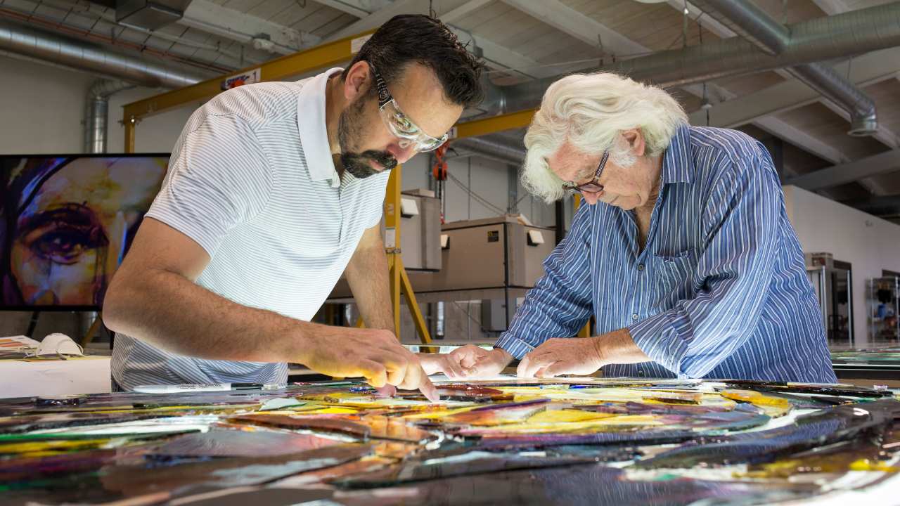 two people assembling stained glass