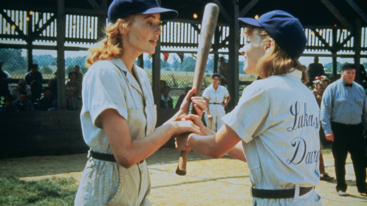 two women in baseball uniforms talking