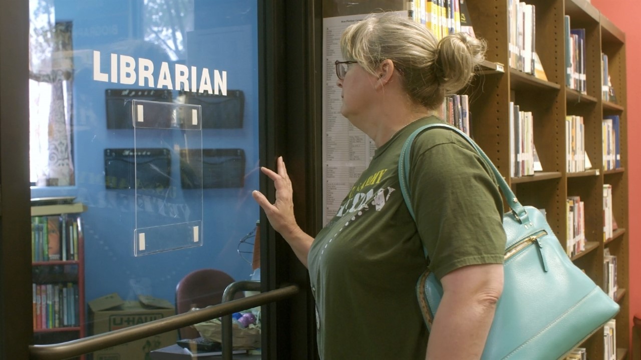 Woman walking through door that says Librarian