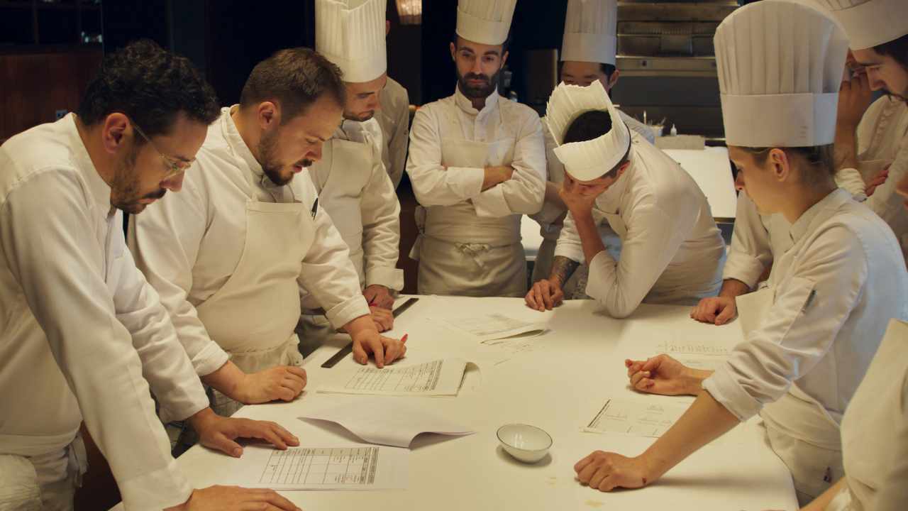 a group of chefs planning out a menu