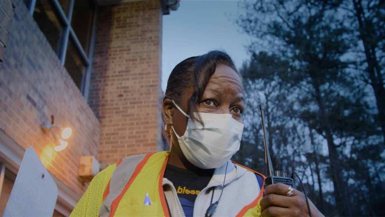 a woman wearing a face maskwith a walkie talkie