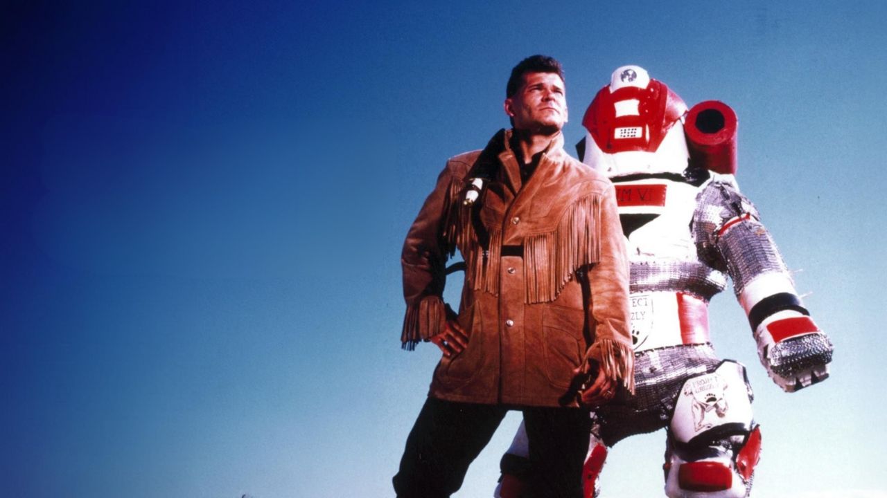 a man standing next to a large padded suit