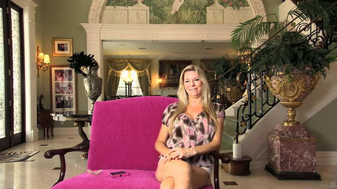 a blonde woman smiling on a fuschia chair