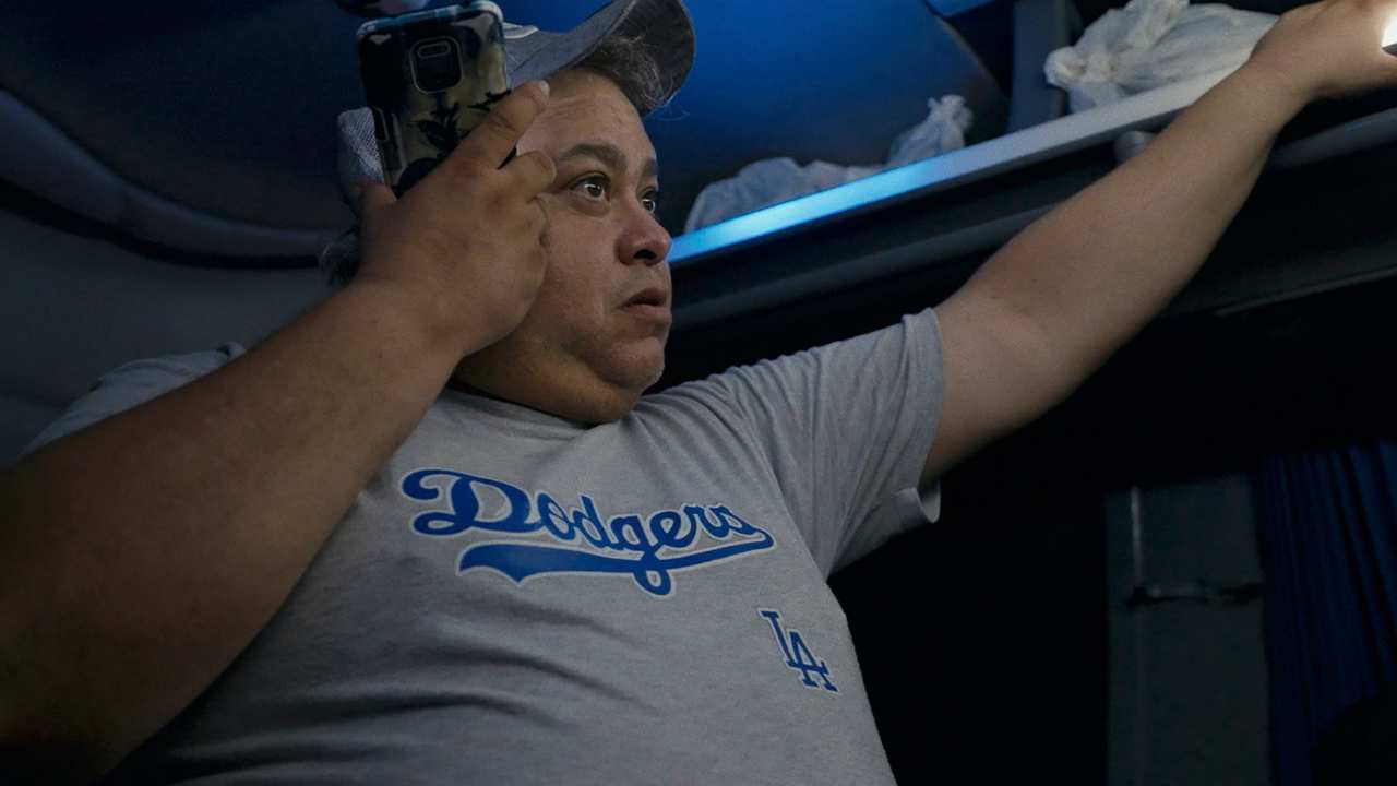 a man with a baseball cap holding his phone