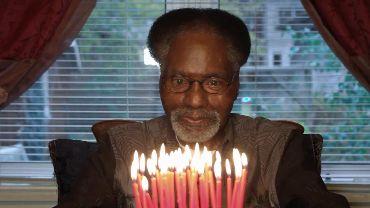 a man with glasses sitting in front of a birthday