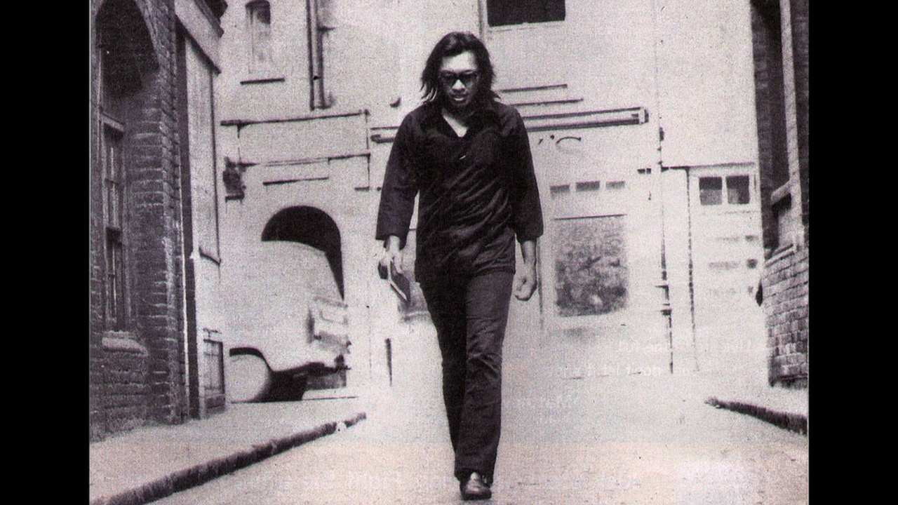 a man with sunglasses walking down a street
