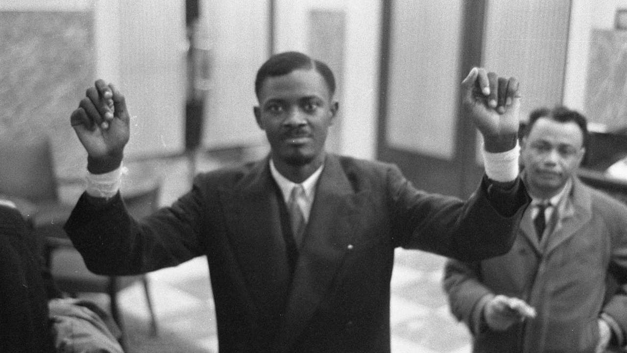 a man in a suit with his hands in the air