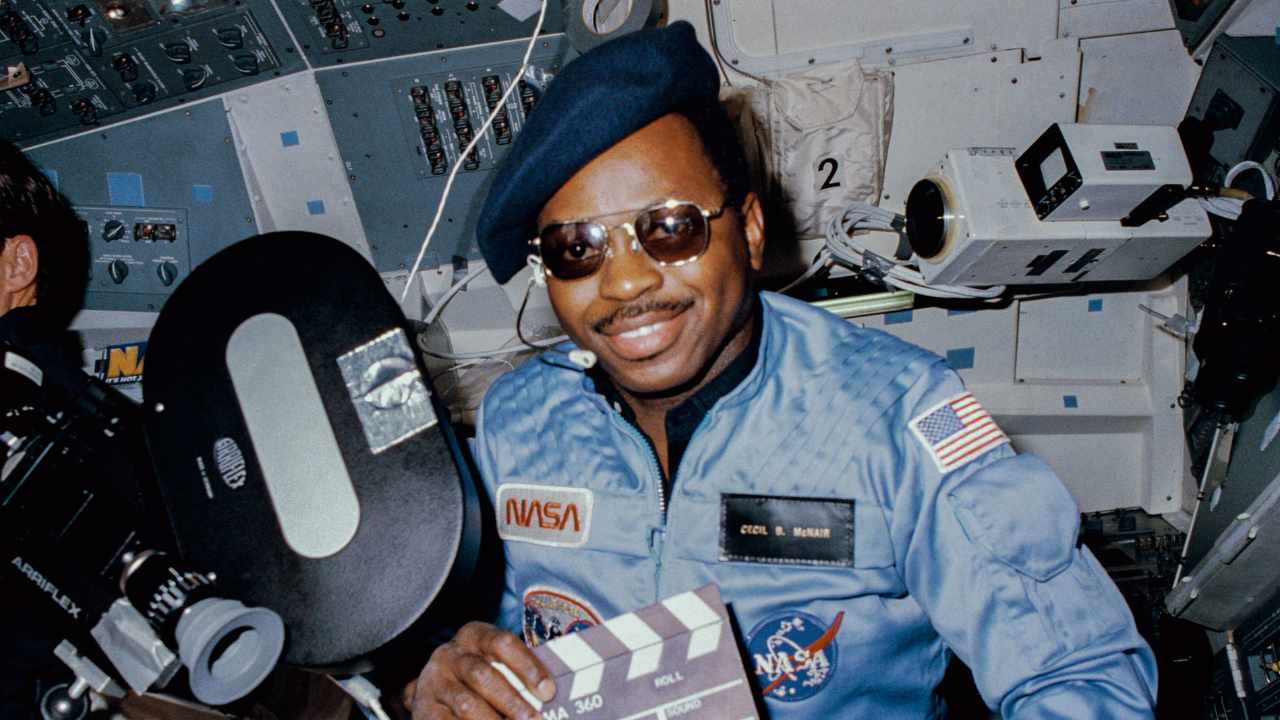 an astronaut wearing sunglasses and smiling