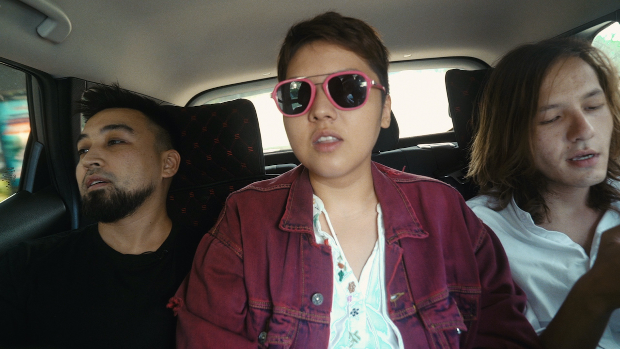Three people sitting in the backseat of a car