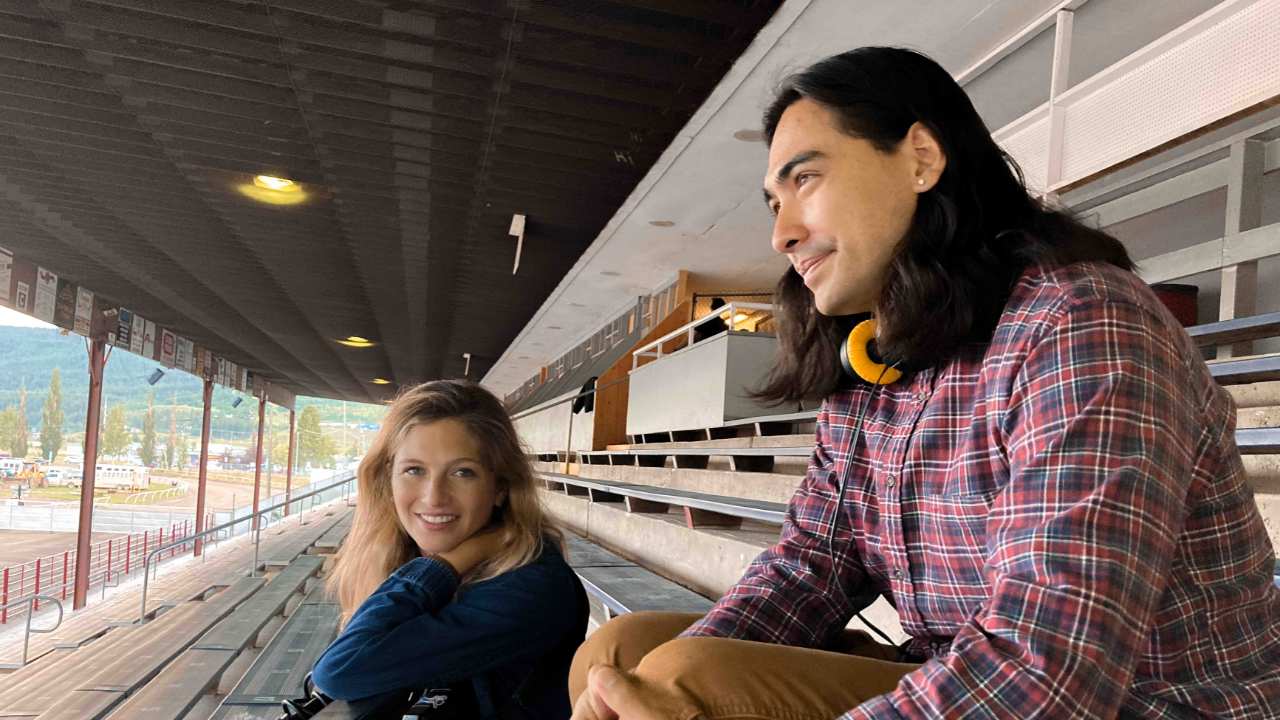 a man and woman sitting together on bleachers