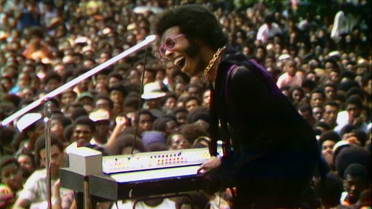 a man singing and playing keyboard on stage