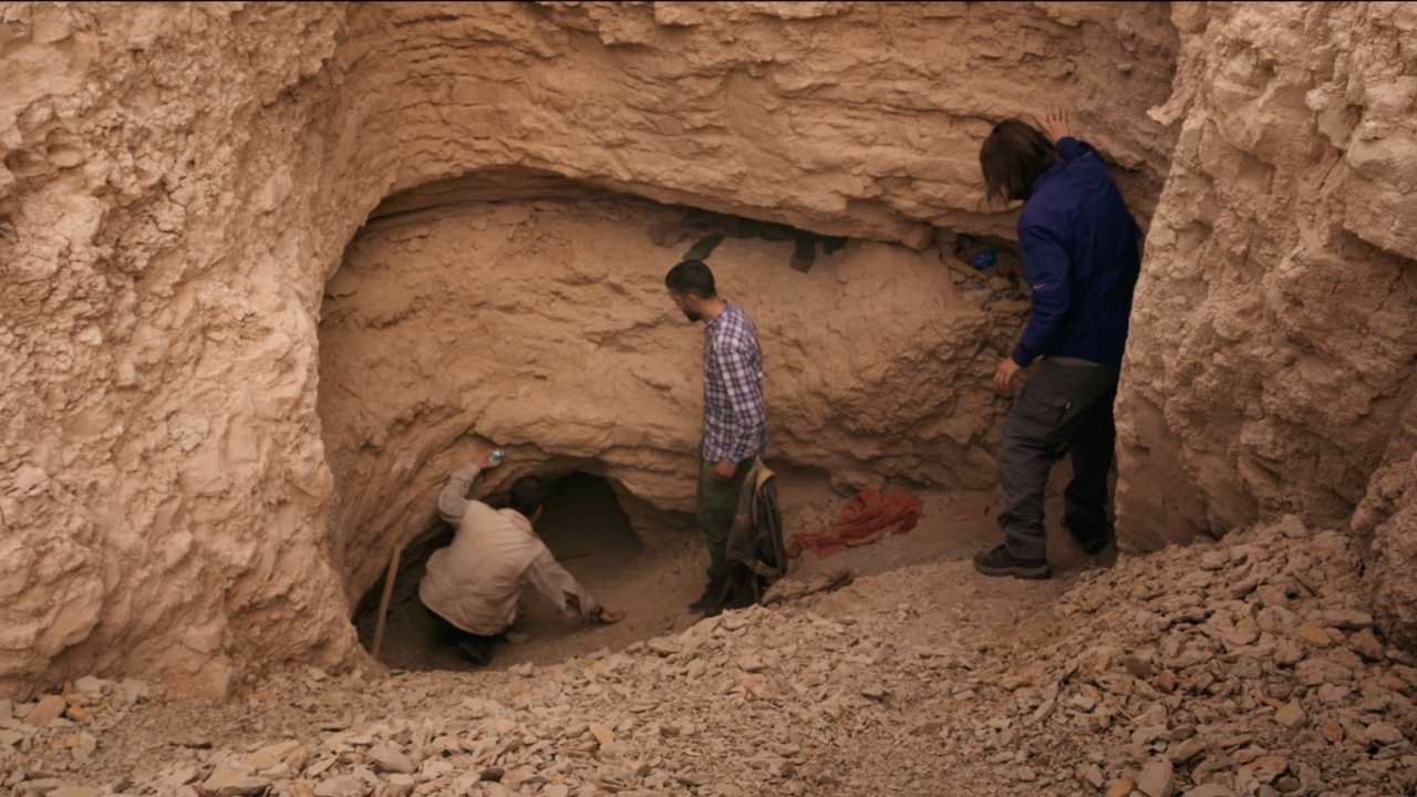 three people at an excavation site