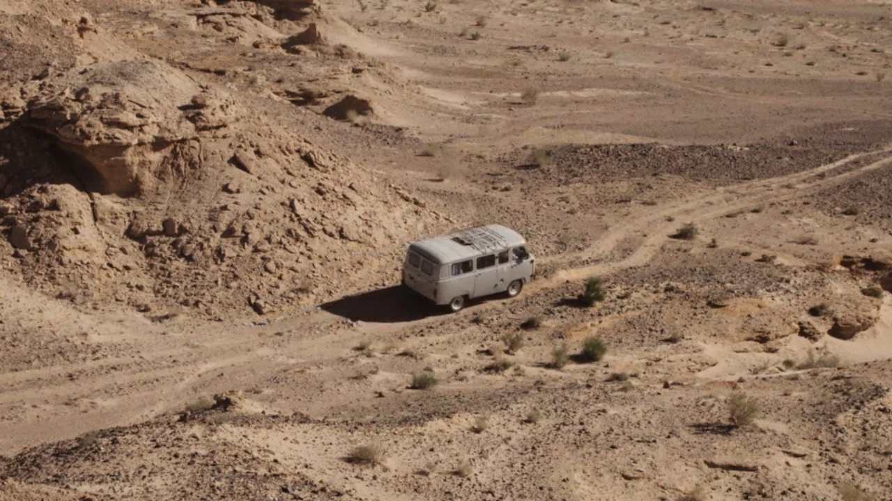 aerial shot of a van driving through the desert