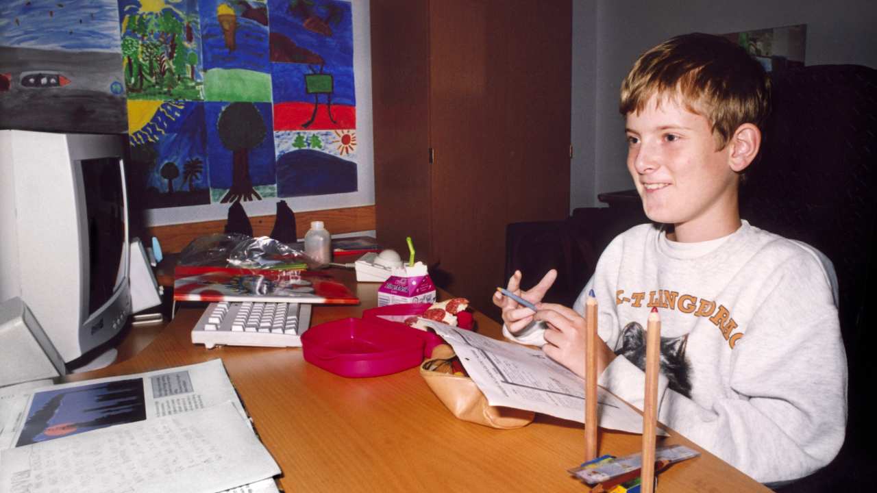 a little boy sitting in front of a computer