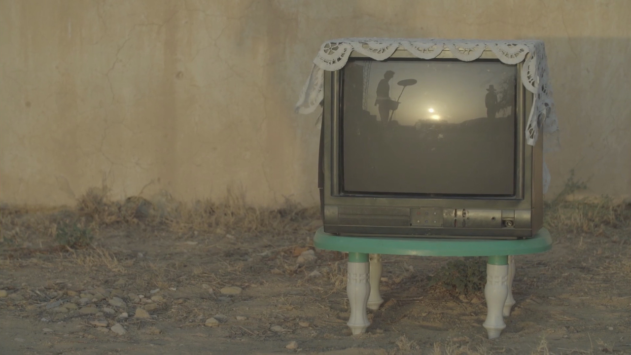 Old, lace-topped television set on a tiny table 